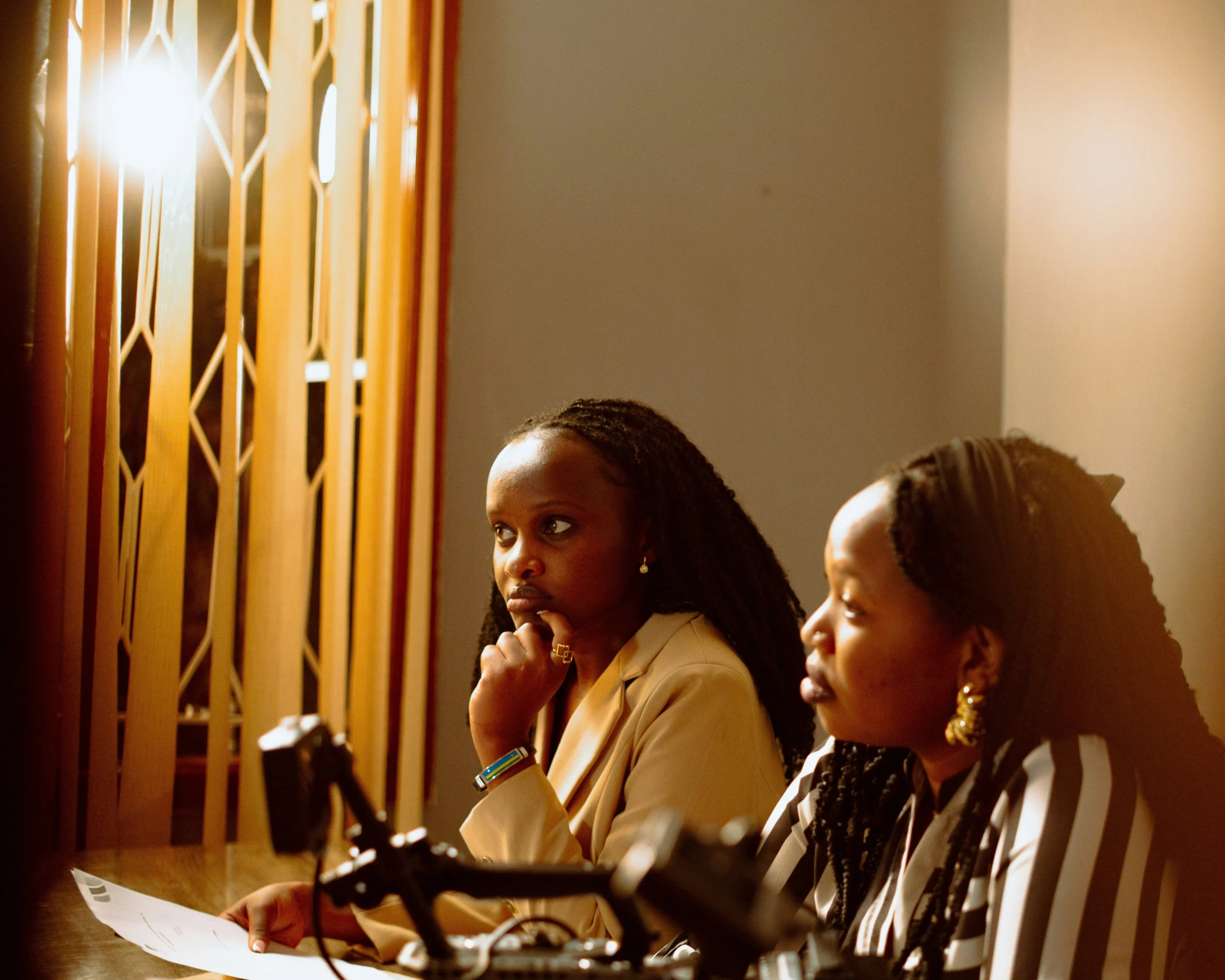 Two women speaking into microphones.